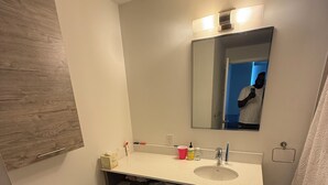 A bathroom with a toilet, sink, mirror, and a shower curtain.