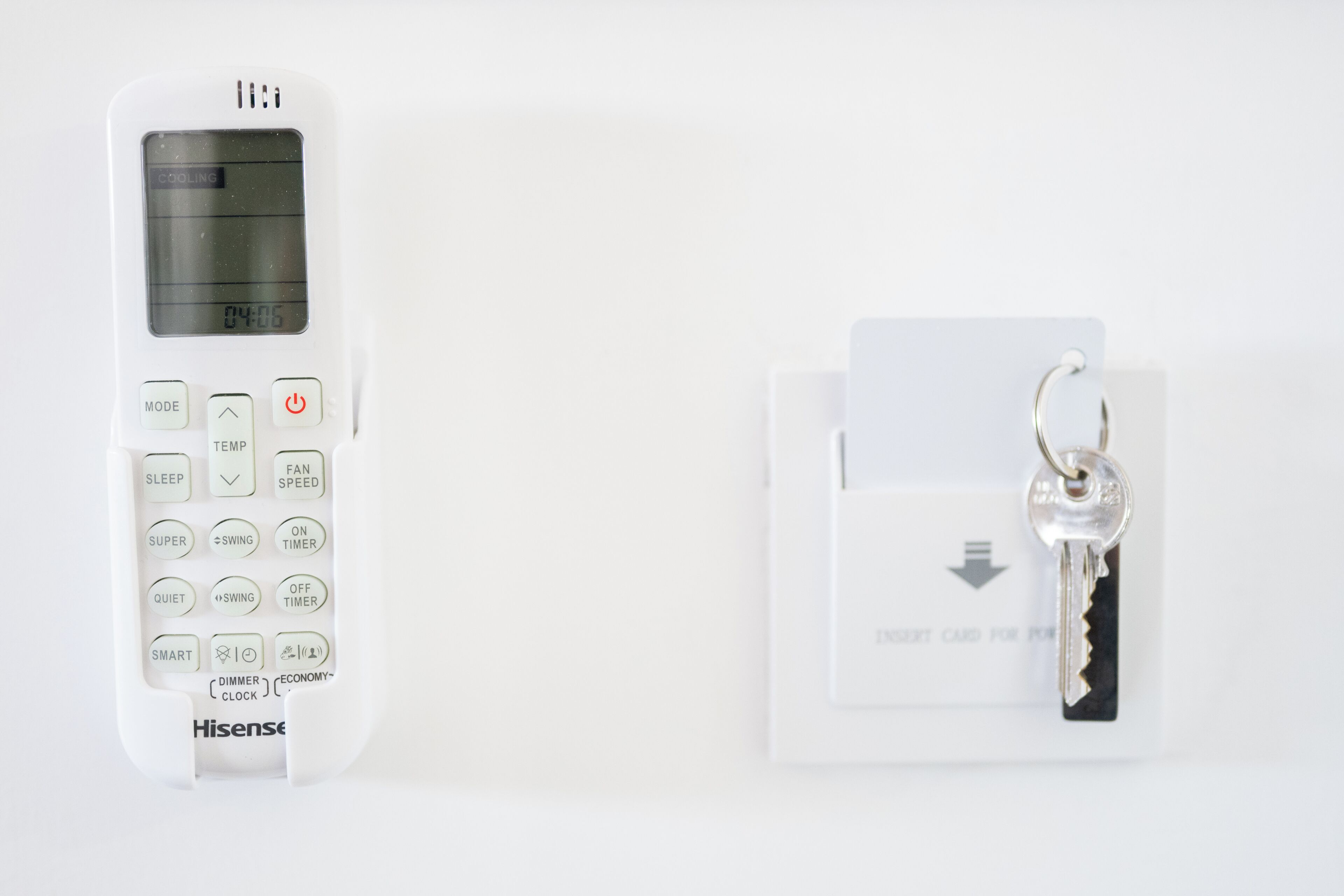 A white Hisense digital clock with a key card slot and a key card inserted.