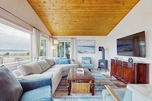 Ein Wohnzimmer mit einem großen Sofa, einem Couchtisch, einem Fernseher und einem Kamin.