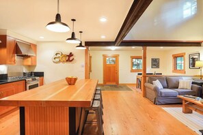Une cuisine avec des meubles en bois, un îlot central et des luminaires suspendus.
