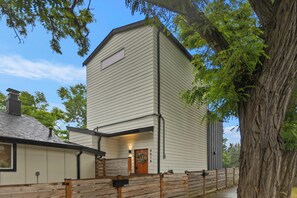 A two-story building with a front porch, a mailbox, and a large tree in the foreground. - World Cup 2026 3BR. Near downtown Seattle attractions. Modern living space (Seattle)
