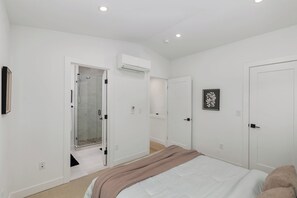 A bedroom with a bed, a shower, and a door with a picture on the wall. - World Cup 2026 3BR. Near downtown Seattle attractions. Modern living space (Seattle)