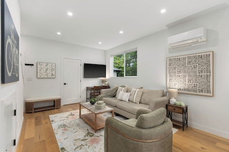 A modern living room with a sofa, coffee table, and a TV mounted on the wall.. World Cup 2026 3BR. Near downtown Seattle attractions. Modern living space