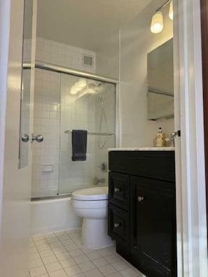 Ein Badezimmer mit Dusche, Toilette und Waschtisch.