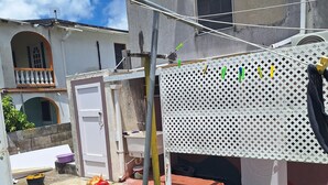 Un quartiere residenziale con un filo per stendere il bucato, un palo di metallo e un edificio con un balcone.