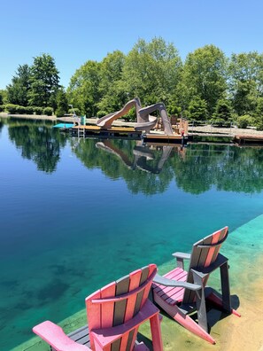 Ein klares Schwimmbecken mit Sprungbrett und Liegestühlen.