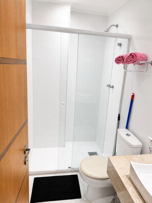 Ein Badezimmer mit Dusche, Toilette und Waschbecken.