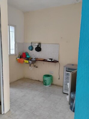 A small kitchen with a window, a sink, a drying rack with pots, a green trash bin, and a metal cabinet. - NICE VIEW HOUSE IN CANCUN (CANCUN)