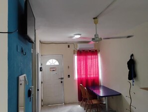 A room with a dining table, chairs, a ceiling fan, an air conditioning unit, and a door with a window. - NICE VIEW HOUSE IN CANCUN (CANCUN)