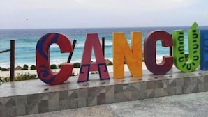 Et farverigt skilt med ordet 'CANCUN' i store bogstaver.