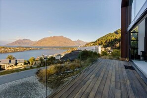 A wooden deck with a view of a lake and mountains. - Stone Ridge: Modern House with Lake Views (Queenstown)
