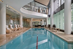 An indoor swimming pool with lounge chairs and a seating area. - Sub Penthouse in Docklands with Breathtaking 180° Views | Pool, Gym & Parking (Docklands)
