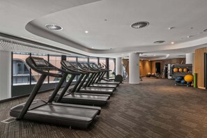A gym with treadmills, exercise balls, and a large window. - Sub Penthouse in Docklands with Breathtaking 180° Views | Pool, Gym & Parking (Docklands)