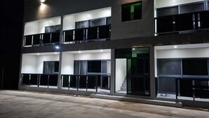 Un immeuble à plusieurs étages doté de balcons, de grandes fenêtres et d’un escalier menant à un niveau supérieur.