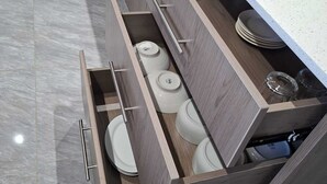 Une cuisine moderne dotée d’appareils électroménagers intégrés, d’un plan de travail et d’un tiroir contenant des ustensiles de cuisine.