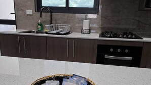 Une cuisine avec une fenêtre, des appareils en acier inoxydable et un panier posé sur le plan de travail.