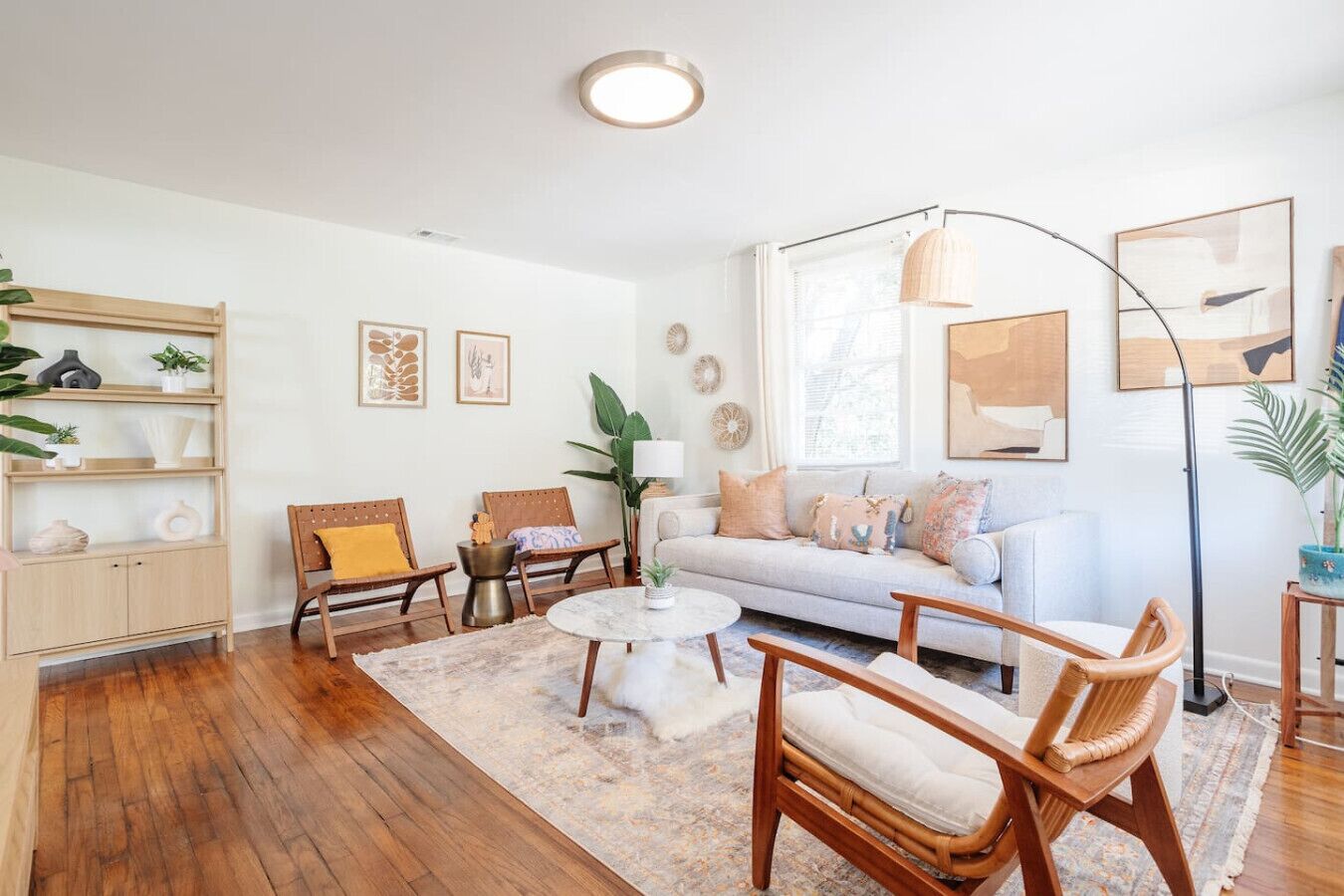 A living room with a sofa, chairs, a coffee table, a floor lamp, and a bookshelf.. 2BR Bright & Breezy Home Walk to Hospital, near DT