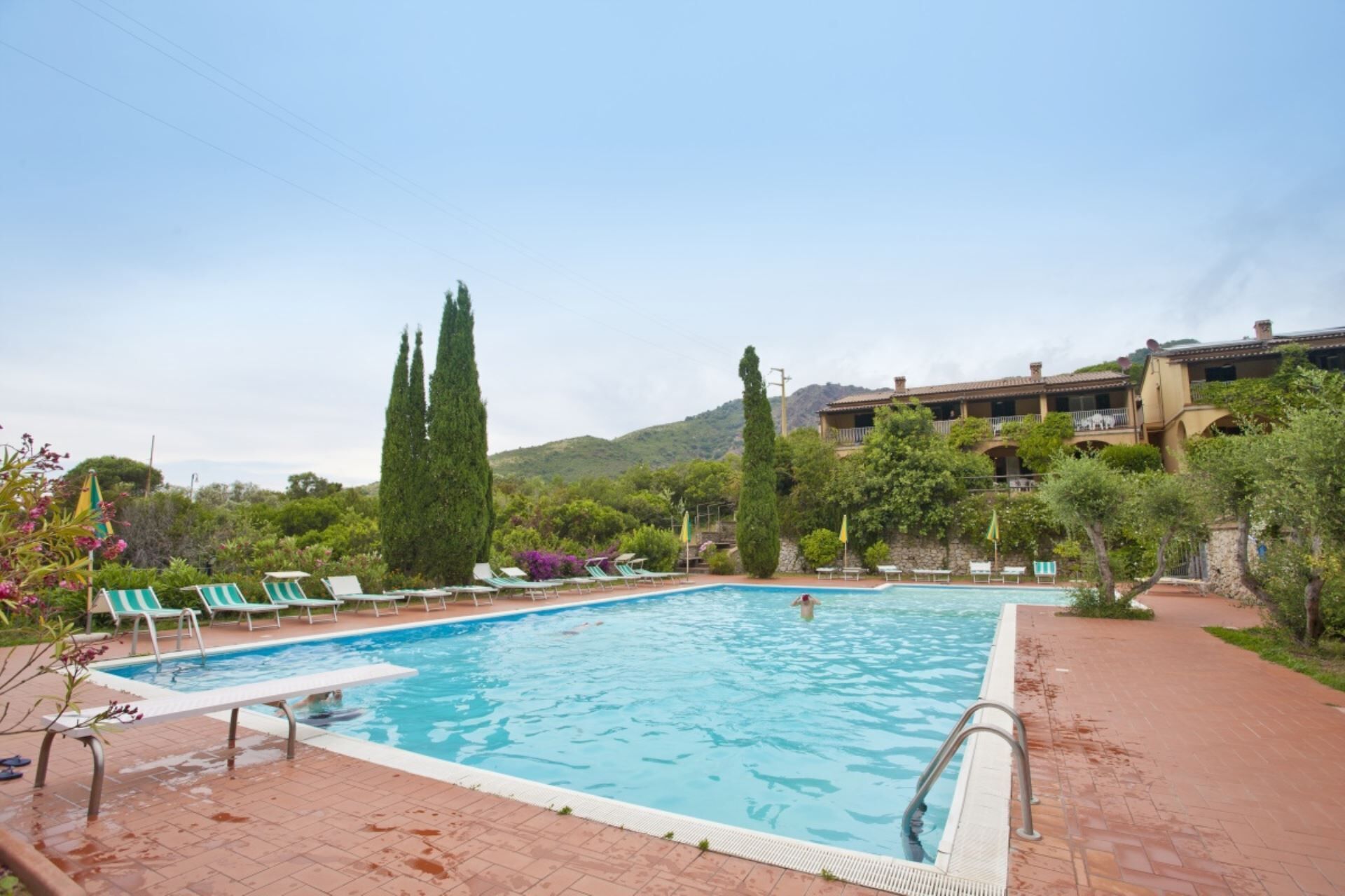 A swimming pool with lounge chairs and a building in the background.