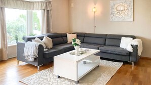 A living room with a grey sofa, white coffee table, and a patterned rug. - 3 bedroom cozy home in ålesund (Ålesund)