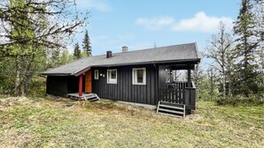 A black wooden cabin with a porch, a chimney, and a number '16' on the door. - Stunning home in Vinstra with sauna (Vinstra)