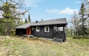 A black wooden cabin with a porch, a chimney, and a number '16' on the door. - Stunning home in Vinstra with sauna (Vinstra)
