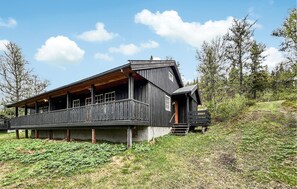 A wooden cabin with a balcony, set on a grassy hillside. - Gorgeous home in Vinstra with sauna (Vinstra)