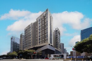 A high-rise building with a modern design, featuring a prominent entrance and multiple floors. - BrisAudio-Visual X Ju (Shenzhen)