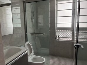 A bathroom with a glass-enclosed shower, a toilet, a sink, and a window with blinds. - BrisAudio-Visual X Ju (Shenzhen)
