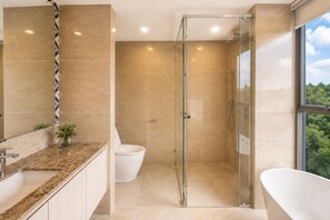 A modern bathroom with a glass shower enclosure, a freestanding bathtub, and a toilet. - New 2 BR Apt Golf View - Ozone 108-156 (Thalang)