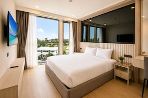 Une chambre d’hôtel moderne dotée d’un grand lit, d’un bureau, d’une télévision et d’un balcon avec vue.