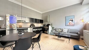 Et moderne køkken med spiseplads, en sofa og et billede på væggen.