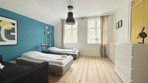 A room with two beds, a desk, a chair, a radiator, and a window with curtains. - City Apartment in Frederiksberg with 3 bedrooms sleeps 6 (Frederiksberg)