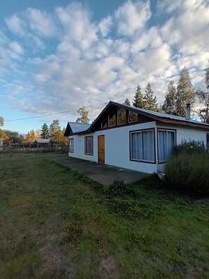 A single-story house with a sloped roof, a front door, and a small porch. - Whole lodge: cabin in Los Angeles, Chile 7 guests 3 bedrooms (los angeles)