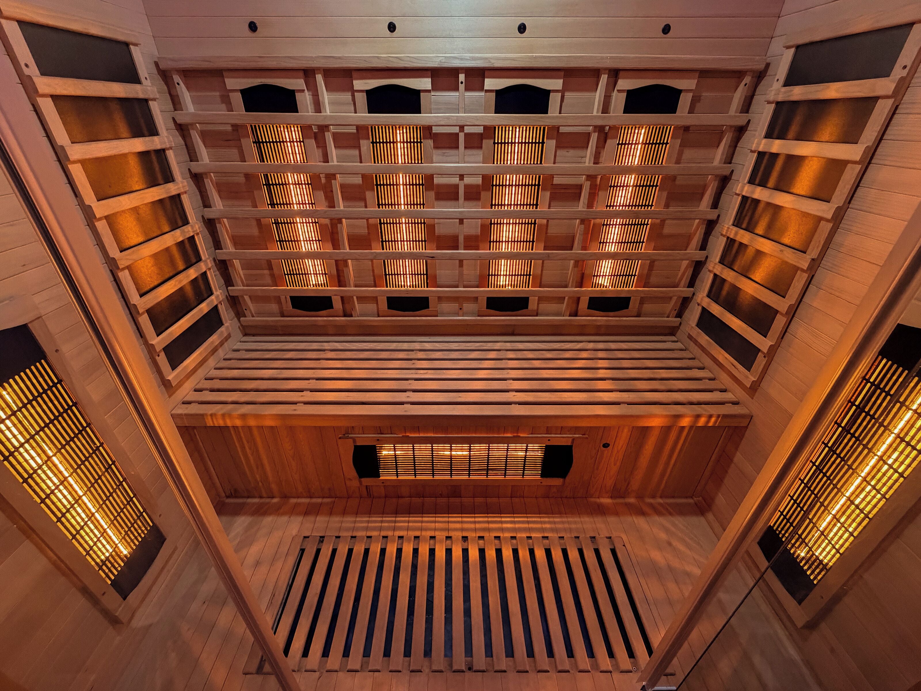 Un interior de madera de varios niveles, con techos de listones y un espacio central abierto.