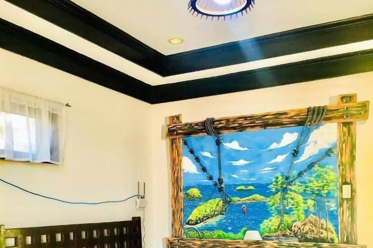 A bedroom with a wooden bed, a hanging hammock-style window, and a ceiling light fixture.