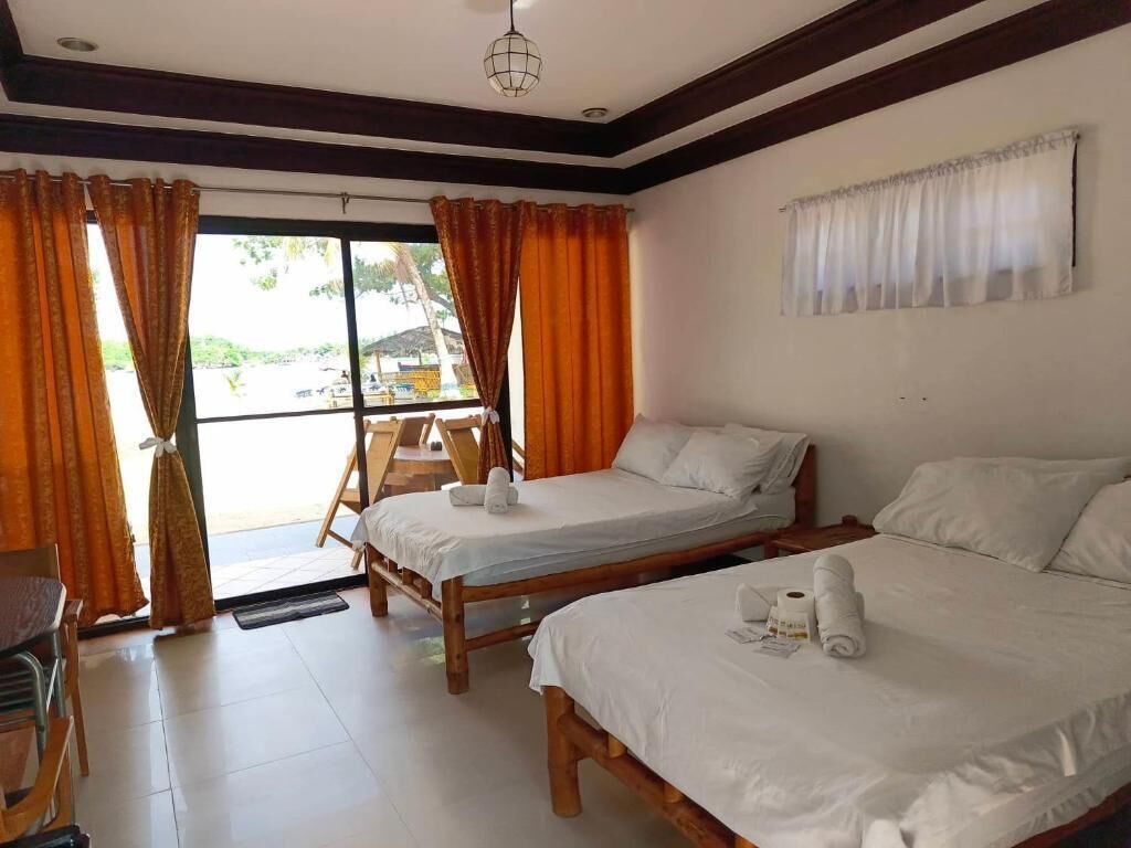 A room with two wooden beds, a chair, and a window with curtains.
