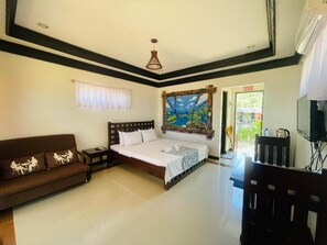 A bedroom with a bed, a sofa, a television, and a painting on the wall. - Bolo Hills Beach Club (Alaminos)