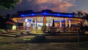 Un restaurante con terraza al aire libre, un patio cubierto y un letrero que dice 'Gregory's'.