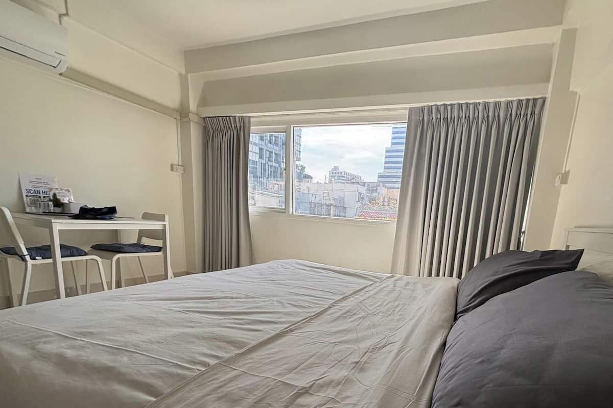 Una habitación de hotel con una cama, un escritorio y una silla.