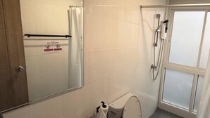 A bathroom with a sink, toilet, shower, and a mirror. - Prime Silom (Bangkok)