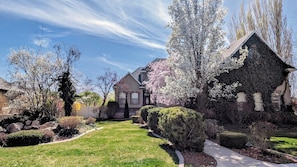 A residential area with a well-maintained lawn, a stone pathway, and houses with distinct architectural styles. - Upper River Cottage - Main Floor & Upstairs, 3-beds, near SF River trail & parks (Spanish Fork)
