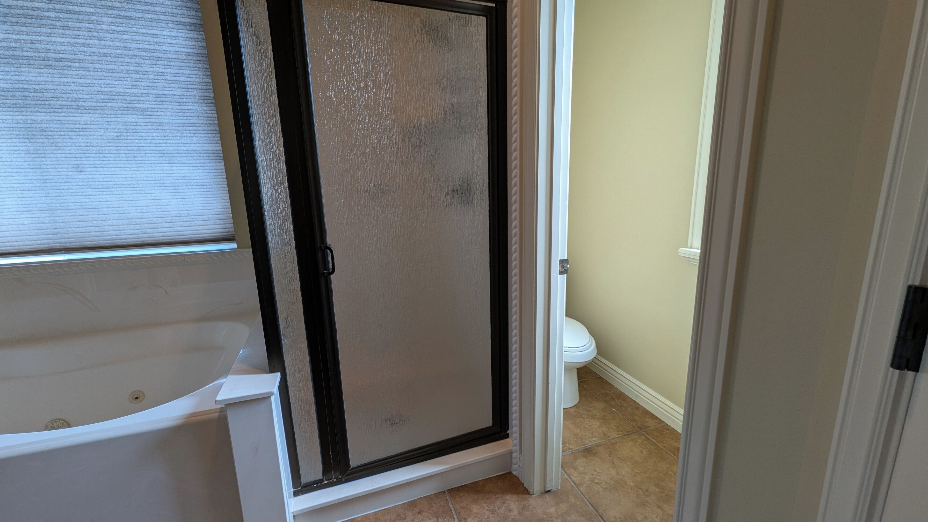 A bathroom with a bathtub, a shower enclosure, and a toilet.
