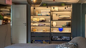 A bedroom with a bed, a bedside table, a wardrobe, and a hanging light fixture.