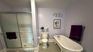 Un bagno con doccia a pavimento, toilette e vasca da bagno freestanding.