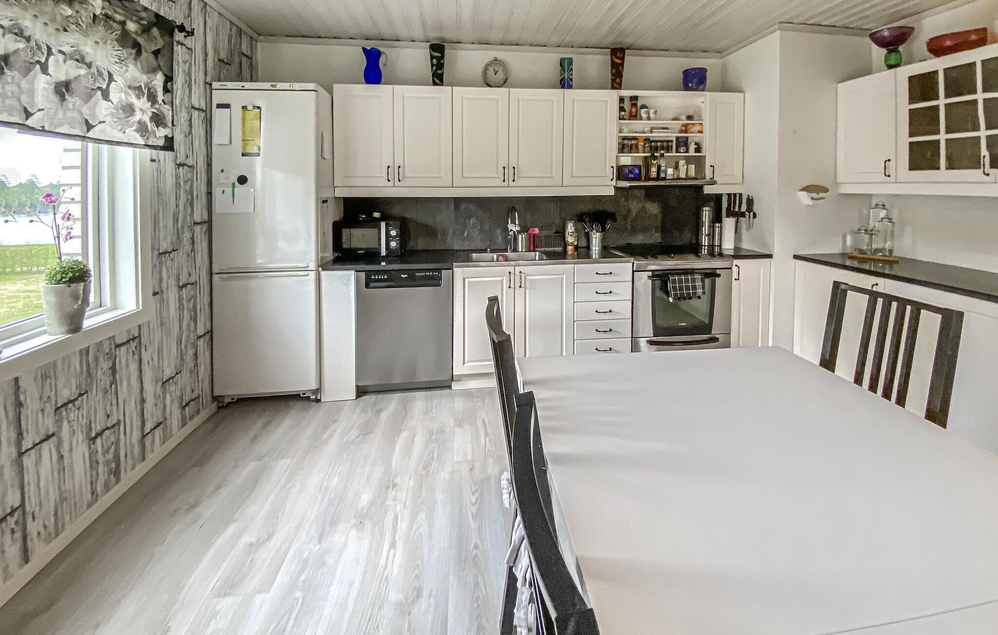 A kitchen with white cabinets, a refrigerator, a dishwasher, a microwave, and an oven.