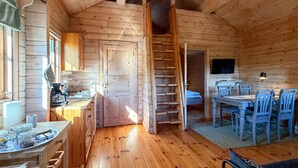 A wooden cabin interior with a kitchen, dining area, and a staircase. - Cozy home in årjäng with sauna (Årjäng)