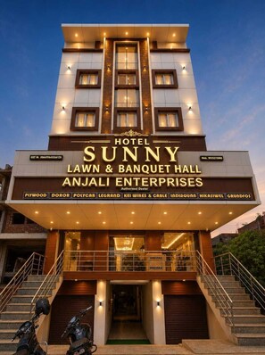 A hotel named 'Sunny Lawn & Banquet Hall' with a modern architectural design, featuring a prominent entrance with steps and a covered area. - Hotel Sunny (Udaypur)