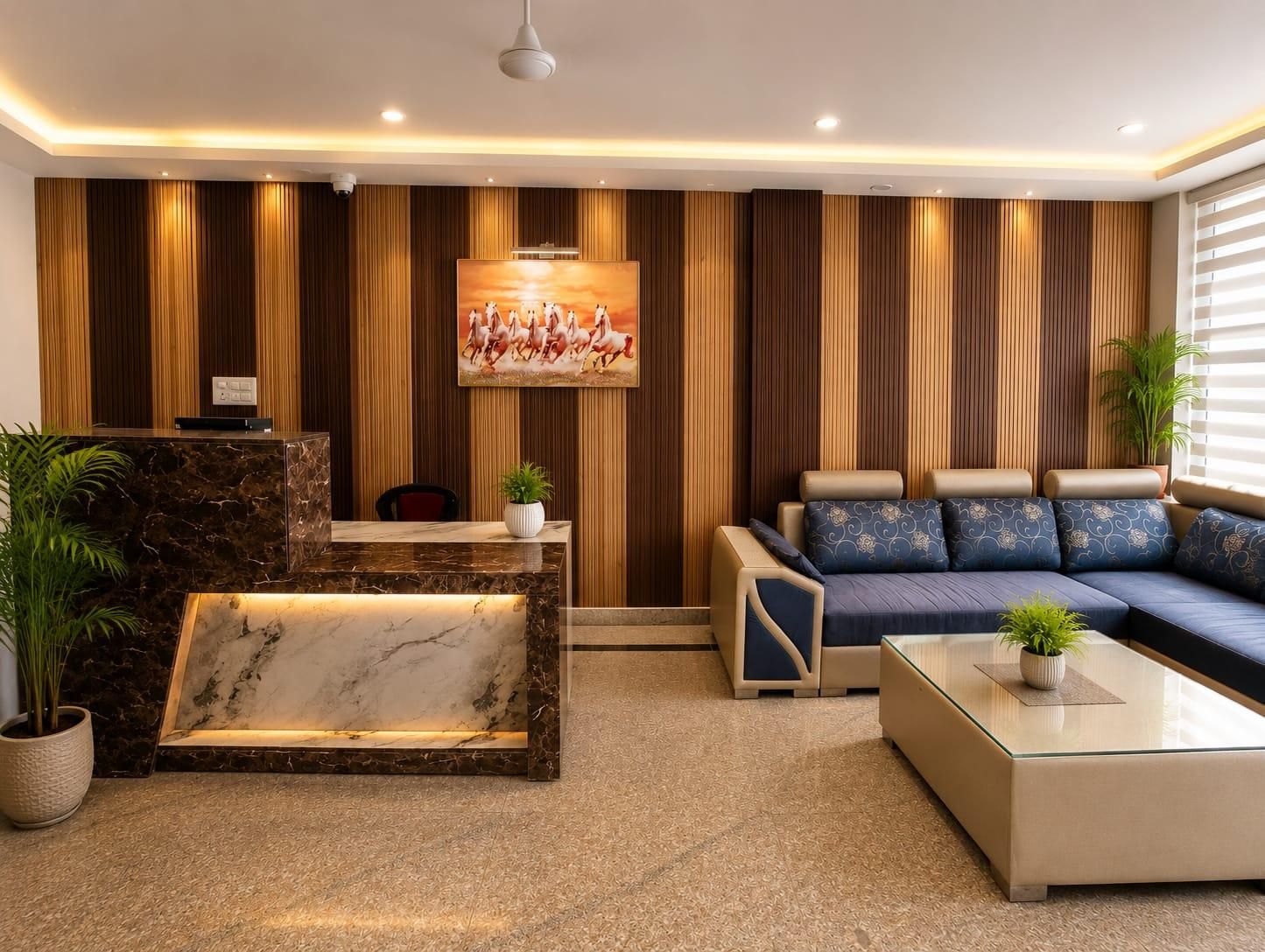 A modern reception area with a marble reception desk, a sofa, and a wall-mounted painting.