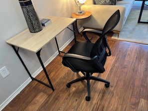 Un espacio de trabajo con escritorio, silla y lámpara.