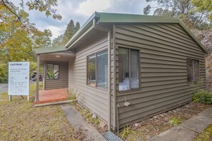 Een gelijkvloers huis met een veranda, een garage en een bord waarop staat dat het wordt geveild.